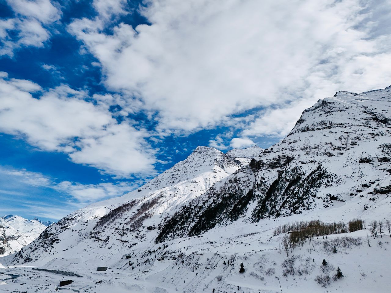 A breathtaking aerial shot of the snow-covered Himalayan mountains in Himachal Pradesh, India.